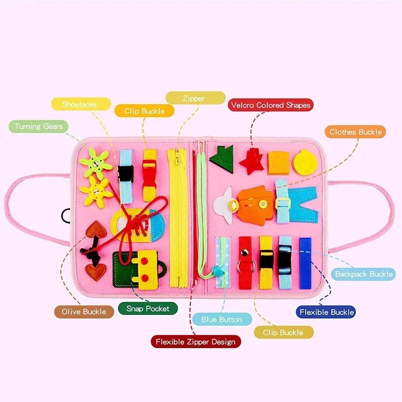 Pink Montessori Busy Board flat open showing labeled activity diagram — shoelaces, zipper, clip buckle, velcro shapes, turning gears, clothes buckle, snap pocket, flexible zipper and more
